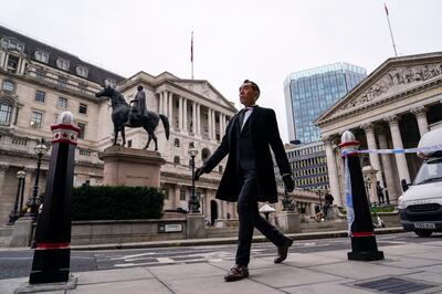 A man walks outside the Bank of England. The central bank raised interest rates for the first time since the pandemic started in December. AP