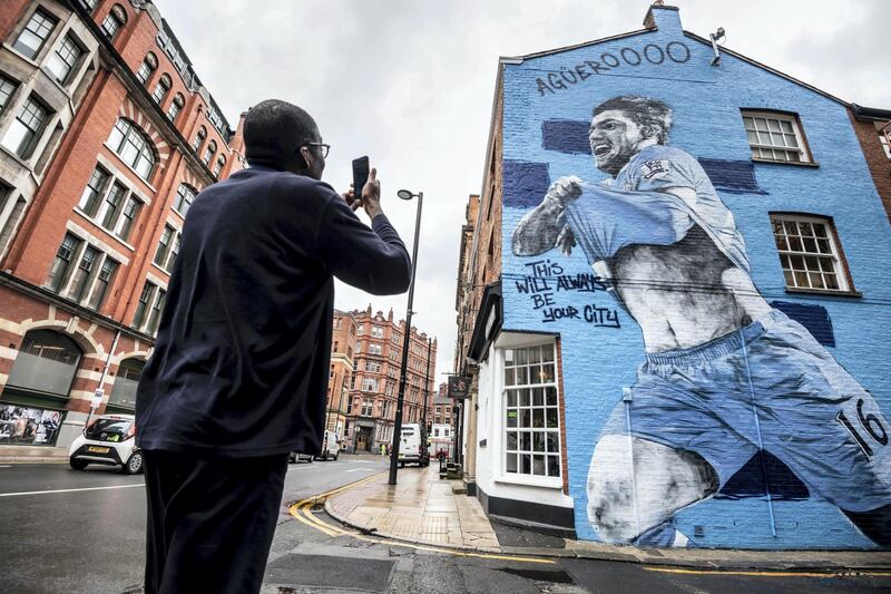 Feature on Manchester City FC at the Etihad complex and Manchester city centre.
PIC shows fan photographs new Sergio Aguero mural on Dale Street.