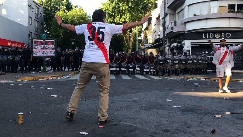 Video grab showing a supporter of River Plate gesturing at riot police. AFP