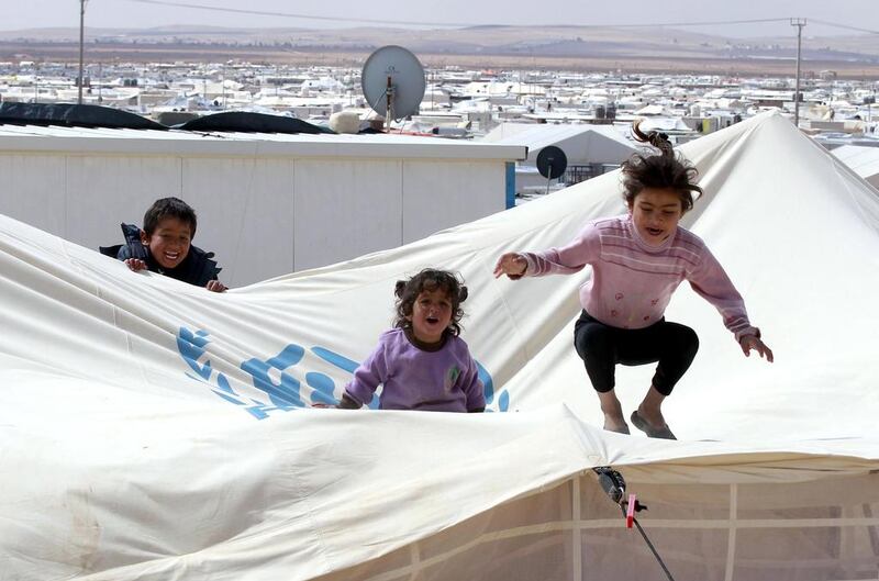 Children playing in the desert Zaatari refugee camp in northern Jordan, near the border with Syria. Khalil Mazraawi / AFP