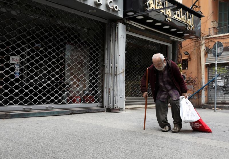 A homeless man walks past closed shops during a countrywide lockdown to combat the spread of the coronavirus disease (COVID-19) in Beirut, Lebanon April 3, 2020. REUTERS/Mohamed Azakir