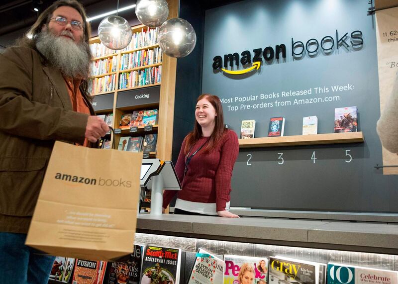 (FILES) In this file photo taken on November 03, 2015 Customers shop at the new Amazon Books store at University Village in Seattle, Washington on November 3, 2015.  Twenty years after pioneering the virtual bookstore, Amazon went brick-and-mortar.   The online giant, which led the bookselling industry's shift to the Internet, opened its first physical bookstore in its hometown of Seattle, Washington.     AFP PHOTO / JASON REDMOND Amazon on March 6, 2019, unveiled plans to open more bookstores and "4-star" shops selling only the best-rated products -- while closing its smaller "pop-up" kiosks in the US. According to CNBC, the 87 pop-up stores in the US will close next month. Launched in 2014, the stands -- located in shopping centers or in other stores, such as Amazon-owned Whole Foods -- offered the company's services and electronics. The announcement confirms Amazon's goal to strengthen its real-world presence with more, larger physical outlets.
 / AFP / JASON REDMOND
