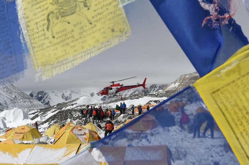Prayer flags frame a rescue helicopter as it ferries the injured from base camp.