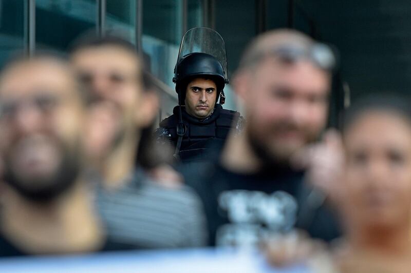 epa07973815 A Lebanese riot policeman stands guard during a protest at the entrance of the MTC Touch building, one of the two mobile operators in Lebanon, in downtown Beirut, Lebanon, 05 November 2019. The protesters who have been closing roads for the third week have started holding protests at the entrances of the state-run institutions.  EPA/WAEL HAMZEH