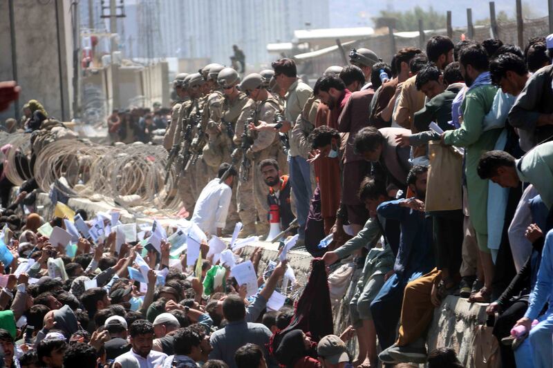 Afghans struggle to reach foreign forces in an attempt to flee the country at Hamid Karzai International Airport in Kabul. EPA