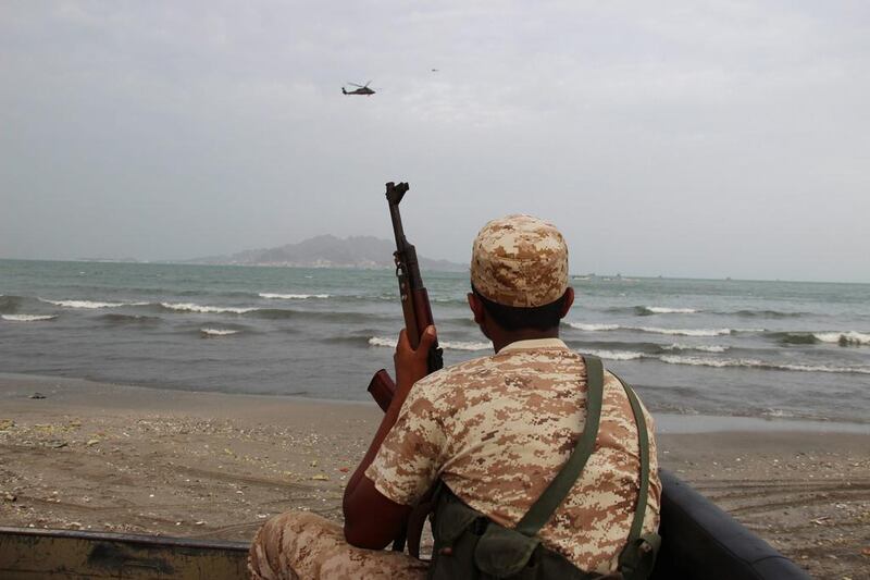 A Yemeni soldier looks on as a UAE military helicopter hovers over the sea off the southern city of Aden (Reuters/Fawaz Salman)