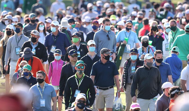The gallery of patrons follows defending champion Dustin Johnson and Rory McIlroy down the third fairway during their practice round for the Masters. AP
