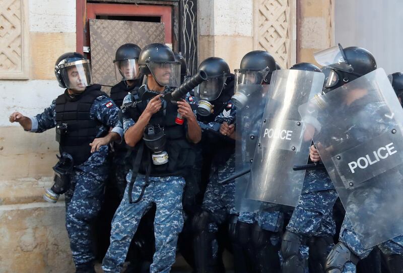 Policemen withdraw as demonstrators throw stones during a protest following Tuesday's blast in Beirut's port area, in Beirut. Reuters