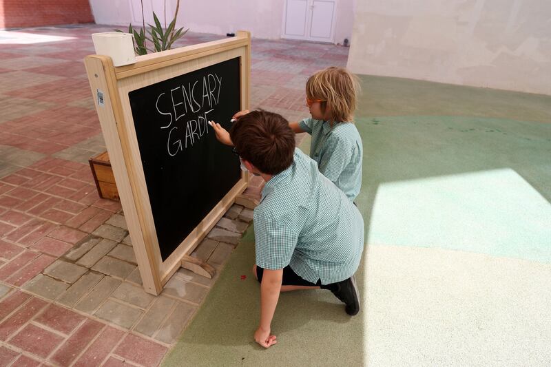 Aspen Heights pupils practise their writing skills in the sensory garden.