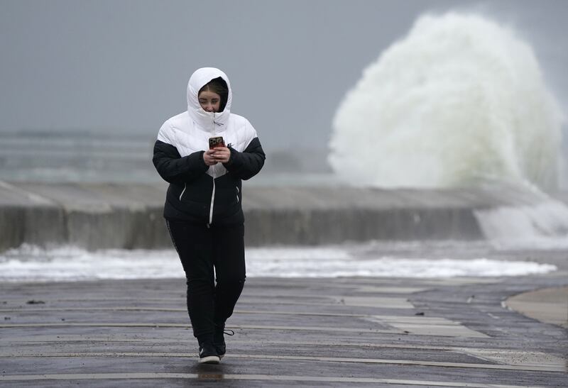 A woman makes her way along the seafront in Southsea. PA