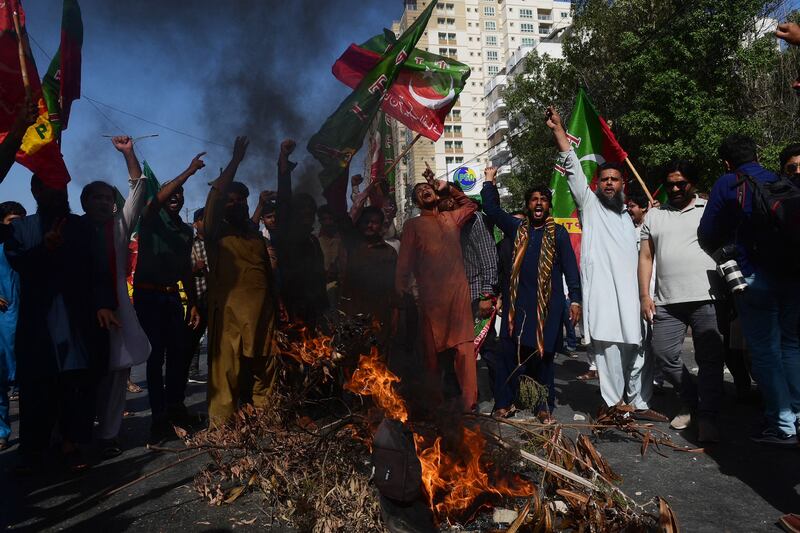Supporters of Mr Khan  block a road during a protest against his arrest. AFP