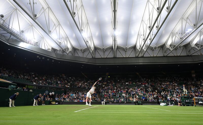 The UK's Andy Murray, a Wimbledon champion, serves to his opponent under the closed retractable roof of Centre Court in 2021.