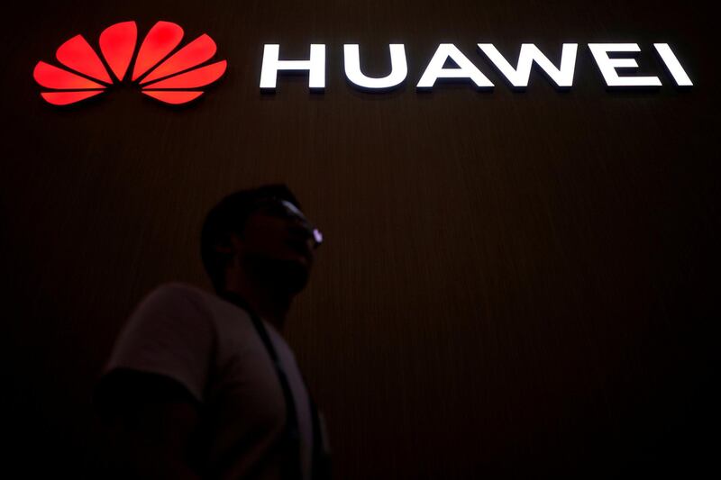 FILE PHOTO: A man walks past a sign board of Huawei at CES (Consumer Electronics Show) Asia 2018 in Shanghai, China June 14, 2018. REUTERS/Aly Song/File Photo