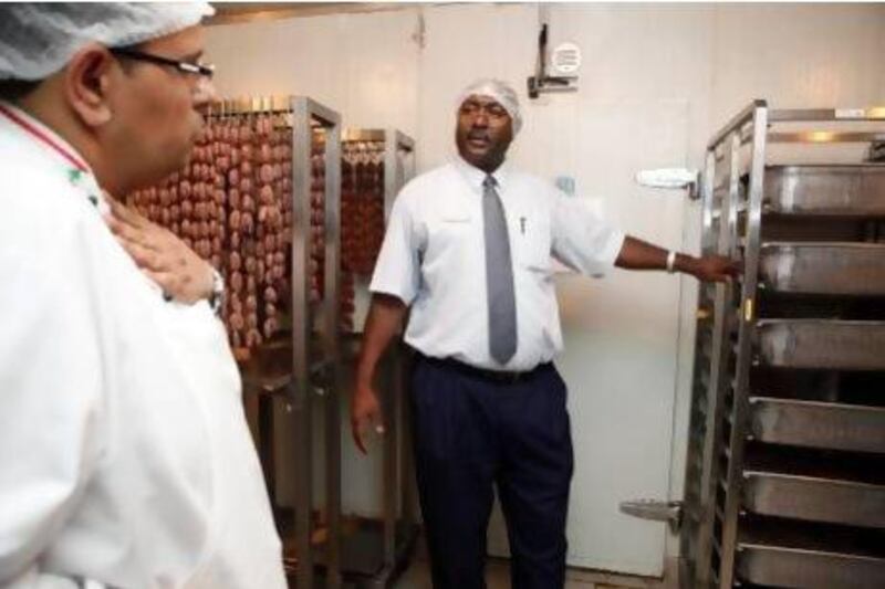 Shining example: Abdelrahim Gader, centre, a senior food inspector with Dubai Municipality’s food control department, inspects a restaurant in Deira last year. He found no infringements. Antonie Robertson / The National