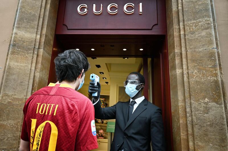 A fan of AS Roma wearing a Francesco Totti jersey undergoes a body temperature scanning procedure as he enters a Gucci luxury shop in Via dei Condotti in central Rome during the country's lockdown aimed at curbing the spread of the COVID-19 infection, caused by the novel coronavirus. AFP