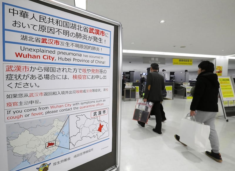 Passengers walk past a notice displayed near a quarantine control station at Narita airport in Narita, Japan.  EPA