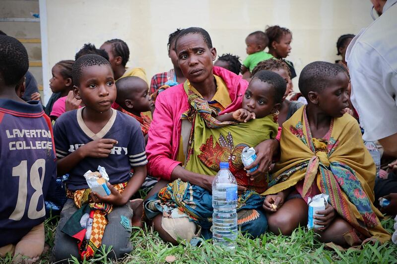 Displaced people receive food and drink after arriving at the airport of Beira in central Mozambique. AFP