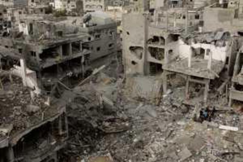 Palestinians stand in the rubble of destroyed buildings adjacent to the house of senior Hamas militant Nizal Rayan after an Israeli airstrike hit a nearby mosque in Jebaliya refugee camp, northern Gaza Strip, Friday, Jan. 2, 2009. Israel showed no sign of slowing a blistering seven-day offensive against Hamas militants in Gaza, destroying homes of the group's leaders and bombing one of its mosques a day after a deadly strike on a prominent Hamas figure killed him and most of his family. (AP Photo/Hatem Moussa) *** Local Caption ***  JRL107_MIDEAST_ISRAEL_PALESTINIANS.jpg