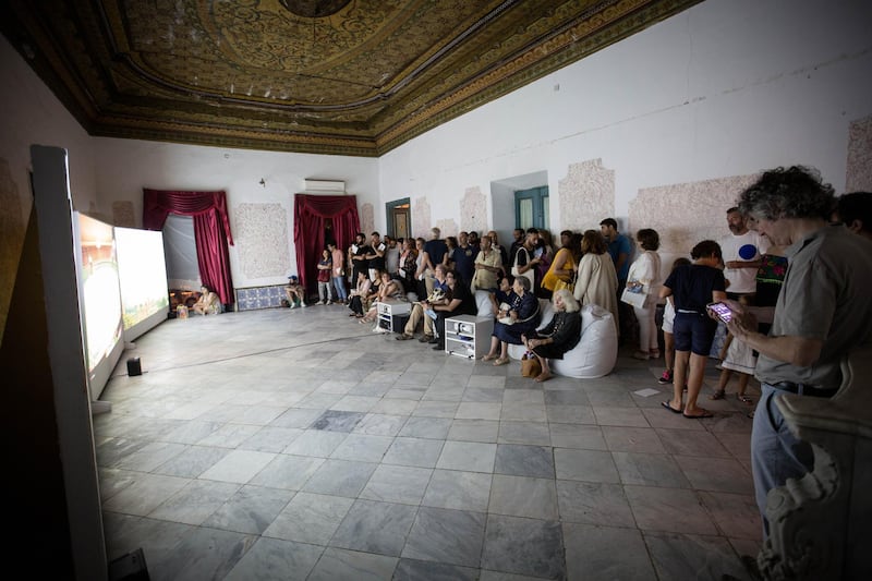 <p>Visitors watching Naeem&nbsp; Mohaiemen&#39;s&nbsp;&#39;Two Meetings and a Funeral&quot; in the Ottoman-era palace that was the venue for the &quot;air&quot; pavilion at Jaou Tunis&nbsp;</p>

