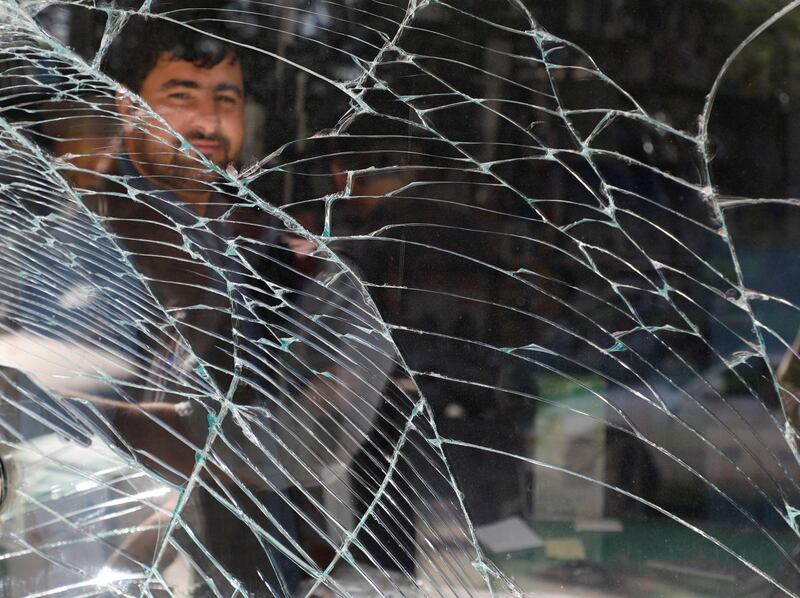 An Afghan man looks through a broken window at the site of an attack in Kabul. Reuters