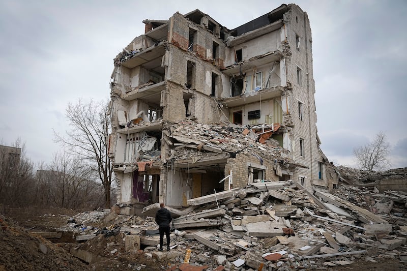 A man looks at his home in a damaged apartment building in Izium, Kharkiv. AP