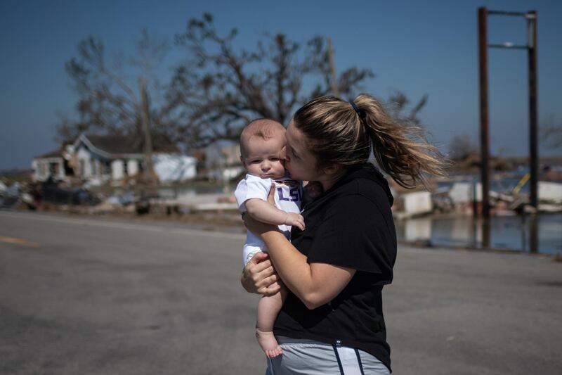 Sarah Adams, 33, kisses her three-month-old son Conner after surveying her family-run lumber yard which was destroyed by Hurricane Delta in Creole, Louisiana, US, October 10. Adrees Latif / Reuters