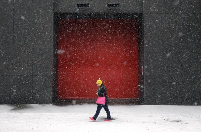 A woman walks outside of an office building on January 21, 2104, as snow falls in Baltimore., Md. Thousands of flights were cancelled, students got an extra day off from school or were sent home early, and the federal government closed its offices Tuesday in the Washington, DC area as another winter storm bore down on the mid-atlantic and northeastern United States. Patrick Semansky / AP photo