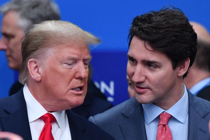 TOPSHOT - US President Donald Trump (L) talks with Canada's Prime Minister Justin Trudeau during the plenary session of the NATO summit at the Grove hotel in Watford, northeast of London on December 4, 2019. / AFP / Nicholas Kamm
