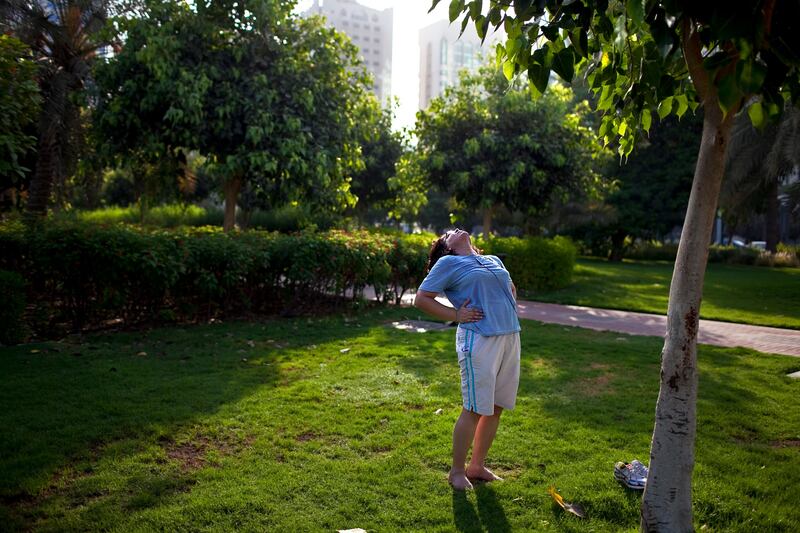 Leaning back in a stretch, Annette Menezes, closes her eyes to bask in the early-morning sunlight while she exercises afer her daily walk in  the Family Park in the Khalidiyah neighborhood in Abu Dhabi on a Tuesday morning, August 2, 2011. Menezes, 47, an Indian form Mangalore, comes to the well-maintained park every morning in search of sunlight before it gets too hot, the sounds of birds and in need of being surrounded by greenery and fresh air. (Silvia Razgova/The National)

