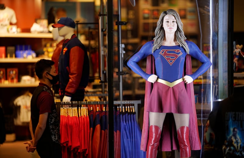 An authentic Supergirl costume is displayed behind glass.