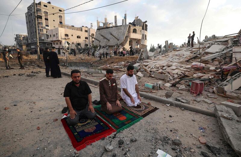 Palestinian Muslim perform the morning Eid Al-Fitr prayer outdoors amid the destruction, following two days of Israeli airstrikes on Gaza, in Beit Lahia in the northern Gaza Strip. AFP