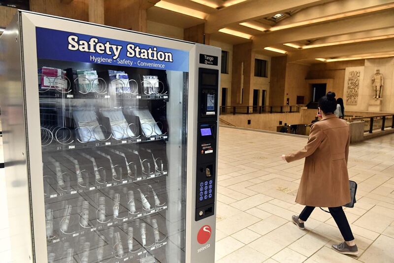 A woman walks past a vending machine selling protective masks and hydroalcoholic gel in the central station in Brussels. AFP