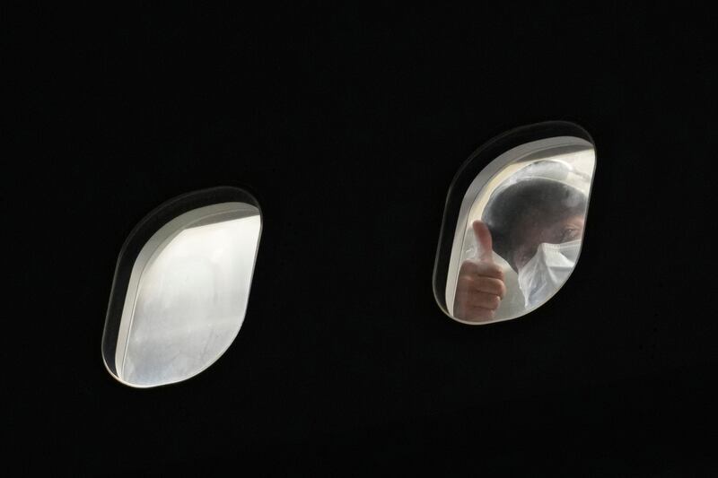 A passenger gives a thumbs up through the window of a plane that had arrived from Afghanistan at RAF Brize Norton air base in England.