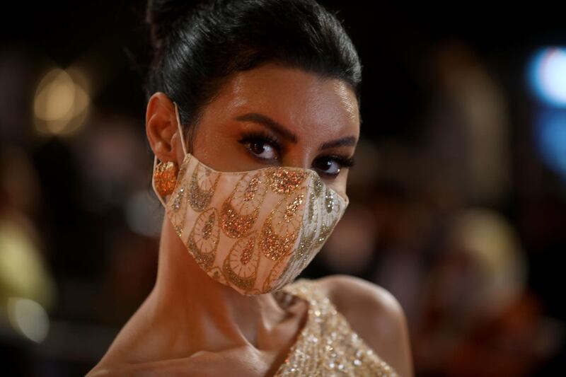 Egyptian actress Arwa Gouda wears a protective mask against the coronavirus as she  walks the red carpet at the opening ceremony of the El Gouna Film Festival. AFP