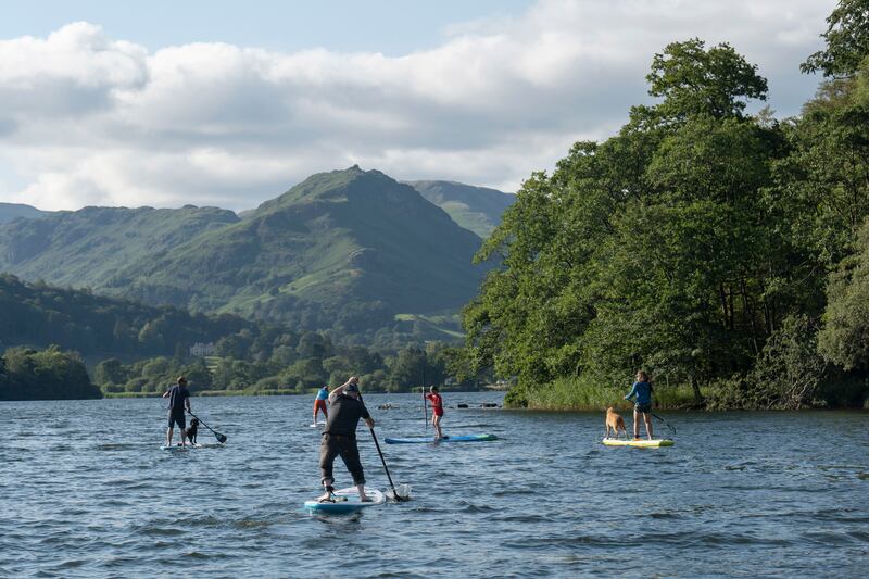 Paddleboarders on Lake Grasmere in the Lake District of England. Getty