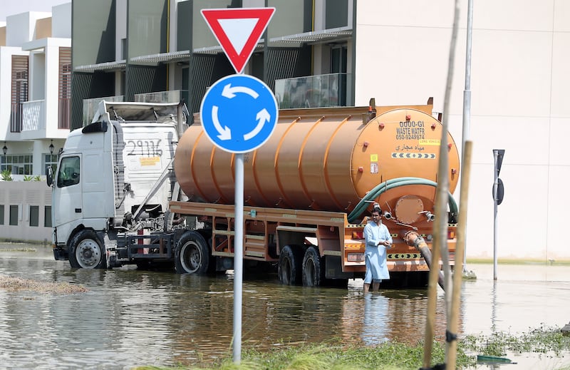 Workers continue to clear flooded roads in Dubai on Monday. Pawan Singh / The National
