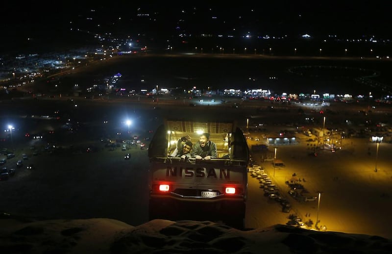 Saudi youths react as their vehicle descends a sand dune. Karim Sahinb / AFP Photo