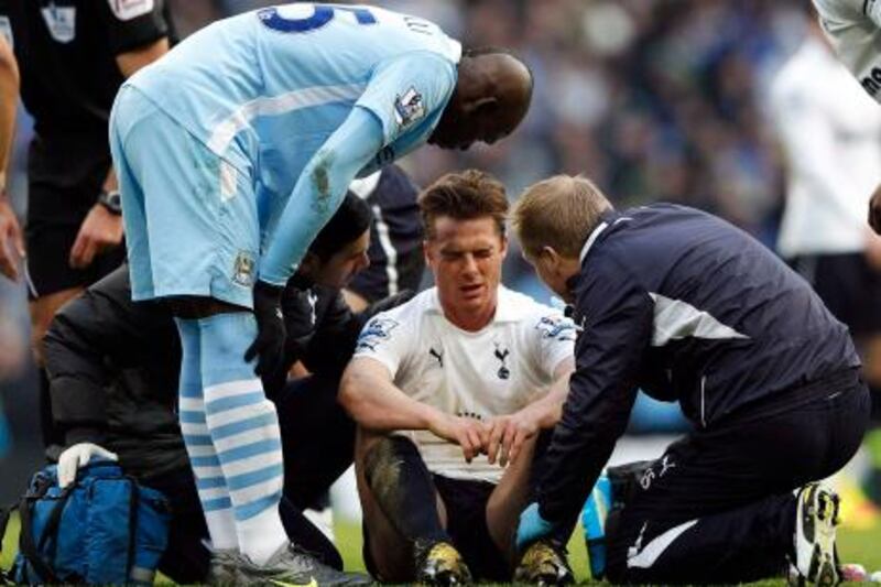 Tottenham Hotspur's Scott Parker (C) receives treatment after a challenge by Manchester City's Mario Balotelli (L) during their English Premier League soccer match at the Etihad stadium in Manchester, northern England, January 22, 2012.   REUTERS/Darren Staples   (BRITAIN - Tags: SPORT SOCCER) FOR EDITORIAL USE ONLY. NOT FOR SALE FOR MARKETING OR ADVERTISING CAMPAIGNS. NO USE WITH UNAUTHORIZED AUDIO, VIDEO, DATA, FIXTURE LISTS, CLUB/LEAGUE LOGOS OR "LIVE" SERVICES. ONLINE IN-MATCH USE LIMITED TO 45 IMAGES, NO VIDEO EMULATION. NO USE IN BETTING, GAMES OR SINGLE CLUB/LEAGUE/PLAYER PUBLICATIONS *** Local Caption ***  MCR16_SOCCER-ENGLAN_0122_11.JPG
