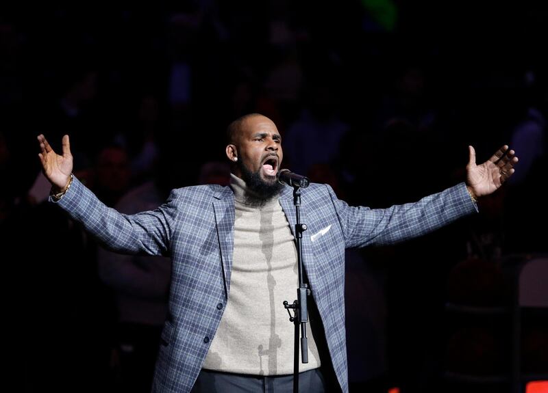 FILE - In this Nov. 17, 2015, file photo, musical artist R. Kelly performs the national anthem before an NBA basketball game between the Brooklyn Nets and the Atlanta Hawks in New York.  The dilemma of separating the sides of R. Kelly, who faces 10 counts of aggravated sexual abuse, now confronts millions who listen to or perform his music.  (AP Photo/Frank Franklin II, File)