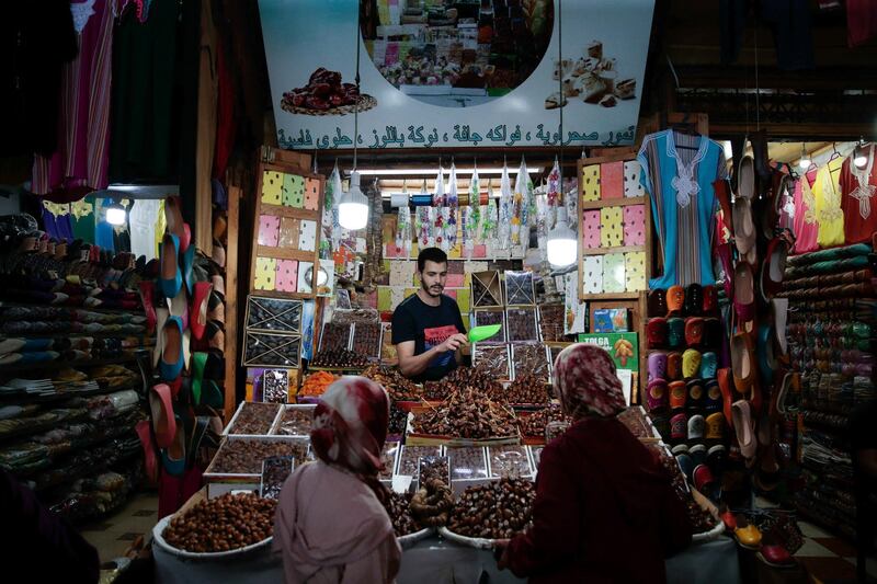 A vendor selling Ramadan sweets speaks to customers in the ancient Medina of Fez, a UNESCO World Heritage Site, in Rabat, Morocco.  AP Photo