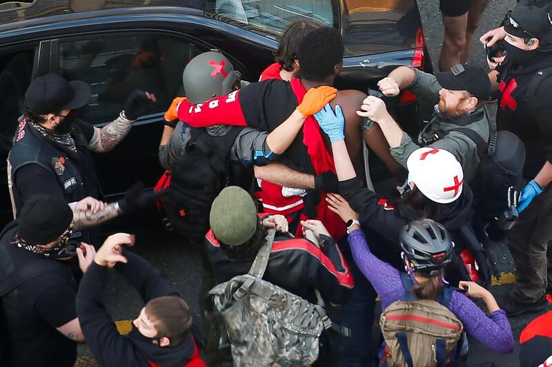 Photojournalist Alex Garland helps apply a tourniquet to the arm of a gunshot victim after a man tried to drive through a crowd and shot one man during a protest against racial inequality in Seattle, Washington. REUTERS