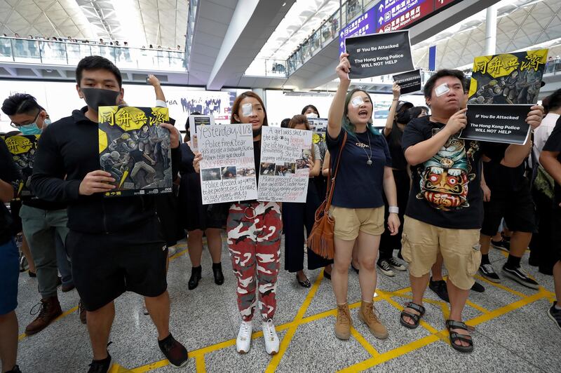 Protesters wear eyepatches during a protest at the arrival hall of the Hong Kong International Airport in Hong Kong.  AP