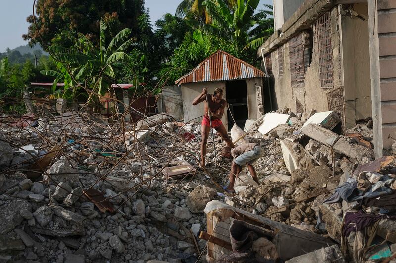 Haitians dig through the rubble of a house that collapsed during the earthquake. AP