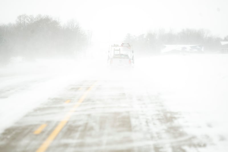Snow blows over an icy road in North Liberty, Iowa. AP