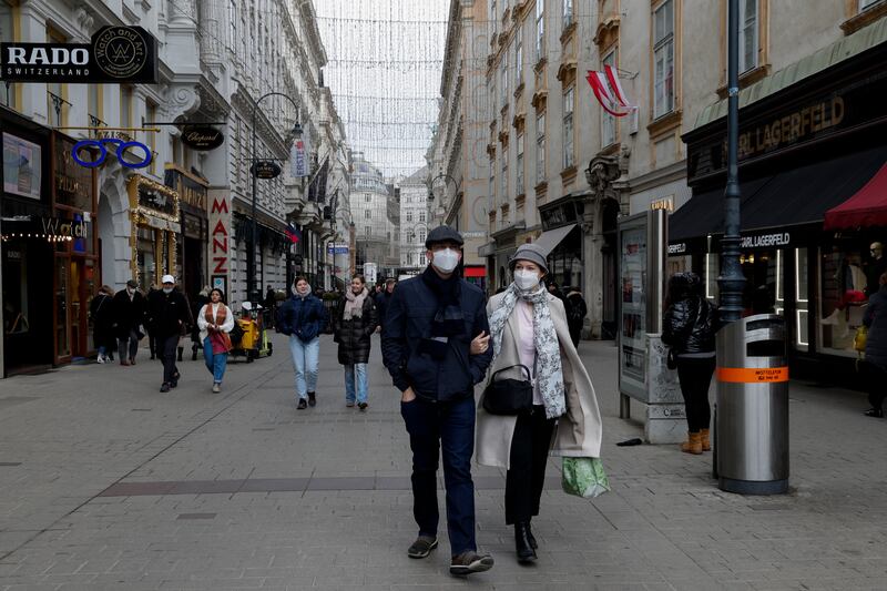 People wearing face masks walk over through a shopping street in Vienna, Austria. Austria is to enter another nationwide lockdown amid soaring infection and death rates. AP photo