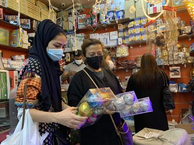 Expats living in Saudi Arabia choose Christmas decorations at a gift shop in the capital Riyadh on December 7, 2020. Until barely three years ago, such items were almost impossible to be openly sold in Saudi Arabia, where authorities have clipped the powers of the clerical establishment long notorious for enforcing Islamic traditions. For decades, Christmas sales were largely underground, and Christians from the Philippines, Lebanon and other countries celebrated the festival behind closed doors or in expat enclaves. / AFP / FAYEZ NURELDINE
