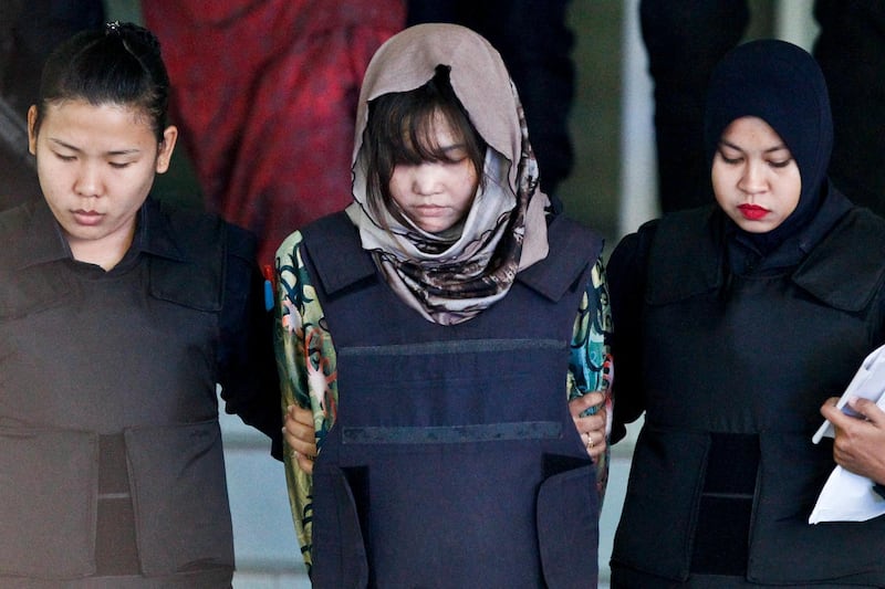 FILE - In this March 22, 2018, file photo, Vietnamese Doan Thi Huong, center, is escorted by police as she leaves after a court hearing at Shah Alam High Court in Shah Alam, Malaysia.  Doan and Indonesiaâ€™s Siti Aisyah, two Southeast Asian women on trial in Malaysia for the brazen assassination of the North Korean leaderâ€™s half-brother could be acquitted Thursday, Aug. 16, 2018, or called to enter their defense in a case that has gripped the world. The two are accused of smearing VX nerve agent on Kim Jong Namâ€™s face in a crowded airport terminal in Kuala Lumpur on Feb. 13, 2017. The women have said they thought they were taking part in a prank for a hidden-camera show. (AP Photo/Sadiq Asyraf, File)