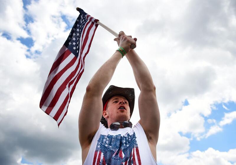 A fan holds an American flag in the infield prior to the 139th running of the Preakness Stakes. Patrick Smith / Getty Images / AFP / May 17, 2014