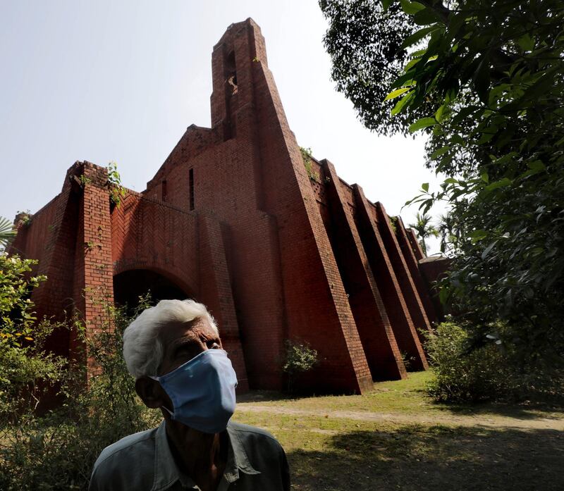 n elderly person uses a protective face mask as he stands guard near a closed church on Good Friday during lockdown near Kolkata, India. EPA