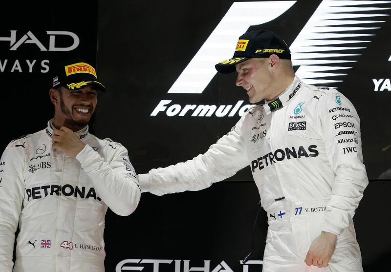 FILE - In this Sunday, Nov. 26, 2017 file photo, Mercedes driver Lewis Hamilton of Britain, left, and Mercedes driver Valtteri Bottas of Finland celebrate after the Emirates Formula One Grand Prix at the Yas Marina racetrack in Abu Dhabi, United Arab Emirates.  Valtteri Bottas has no intention of playing second fiddle to Lewis Hamilton and is aiming to pip his Mercedes teammate to the title. Bottas joined Hamilton at Mercedes at the start of 2017 to replaced Nico Rosberg, following the shock retirement of the then world champion. (AP Photo/Luca Bruno, file)